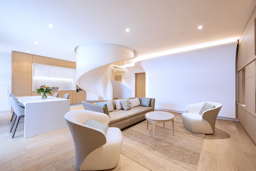 salon dans les tons beige avec en fond un escalier sur mesure en fond