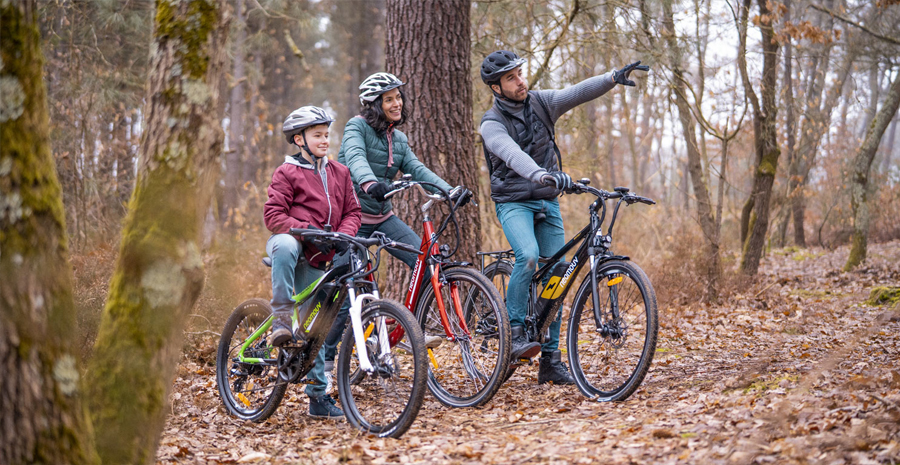 trois personnes dans la foret faisant du vélo