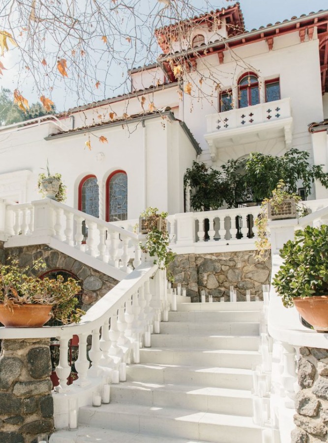 Maison de l'extérieur avec son grand escalier blanc et ses pierres brutes