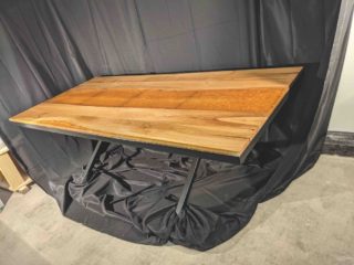 grande table à manger en bois artisanale sur un fond noir