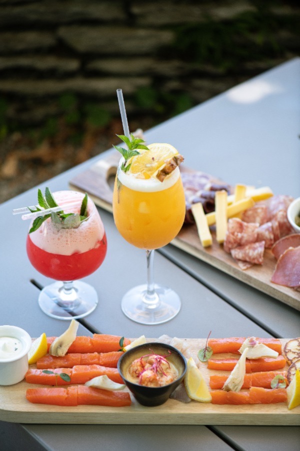 photo de plateau de fromage et charcuterie accompagnés d'un cocktail